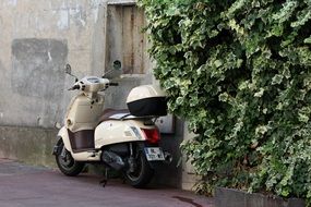 vespa italian scooter near the wall on a street