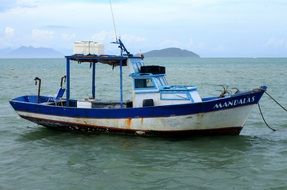 Old fishing boat at sea with hills on horizon