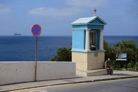 blue building with cross on the sidewalk