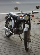 black motorcycle is parked on a paved road