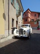 white bentley as a wedding car on a city street