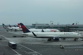 planes are waiting for departure at the airport and cloudy sky above airport on the background