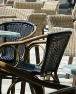 Wicker chairs near tables in an outdoor cafe