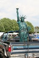 statue of liberty in a trailer of a old car