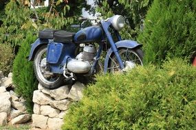 blue motorcycle stands on a stone fence in Bulgaria