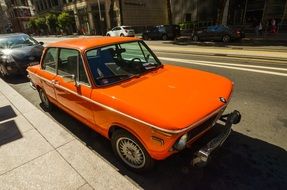 orange retro bmw on sunny street