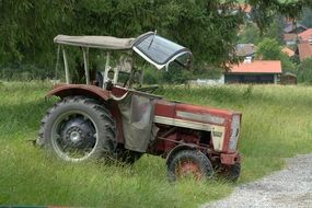 An old tractor stands on the green grass