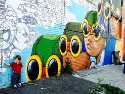 child at the wall with graffiti