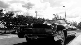 black and white picture of a retro car on the road