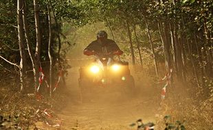 A man riding an ATV on the road at night