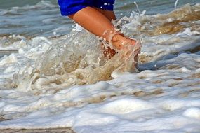 child runs barefoot on the edge of the sea