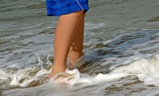 legs of a boy in the sea waves