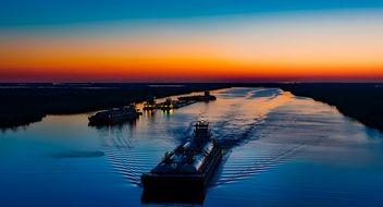 barge sailing along the Sabin Strait against the backdrop of a picturesque sunset