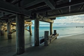 photo of the beach under a wooden pier