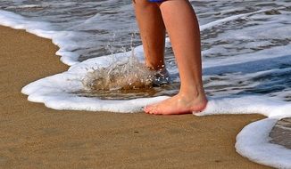 legs of a boy on the wet sand