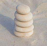 pile of five white Stones on Sand