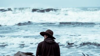 man in wide hat at stormy Sea