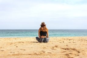 girl meditating on the beach