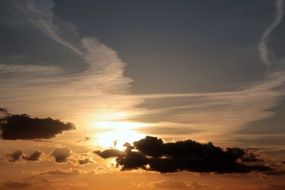 evening sun behind dark clouds