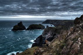 Seascape of Moody Cloudy Grey sky and rocks on a beach