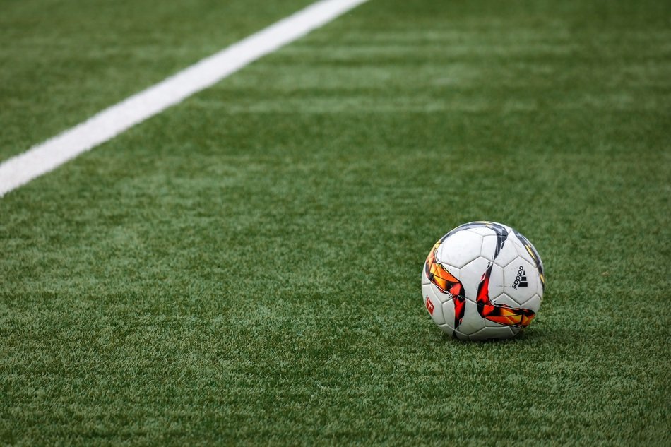Football on pitch near line