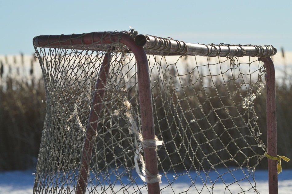 old hockey net on a frozen pond on a sunny day