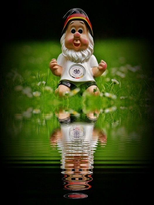 dwarf soccer player is reflected in the water