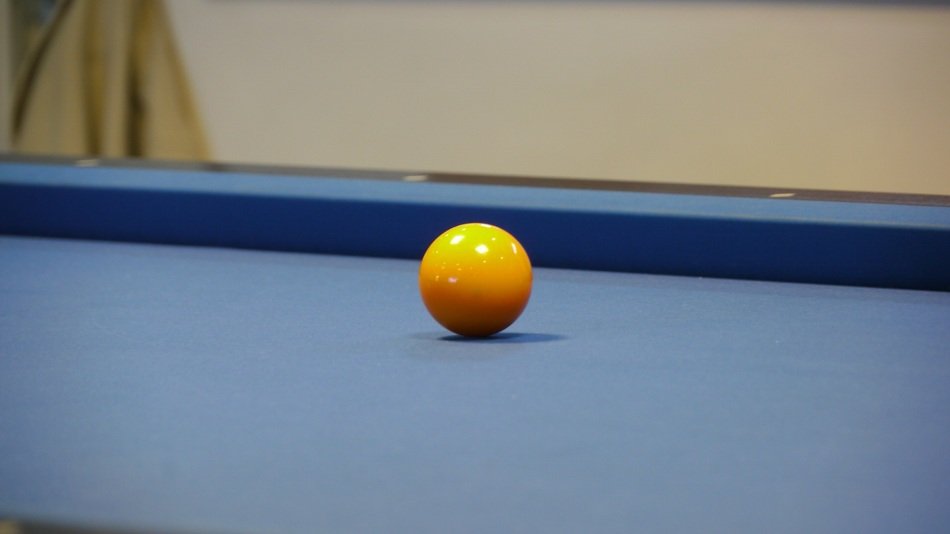 Yellow billiard ball on the blue table
