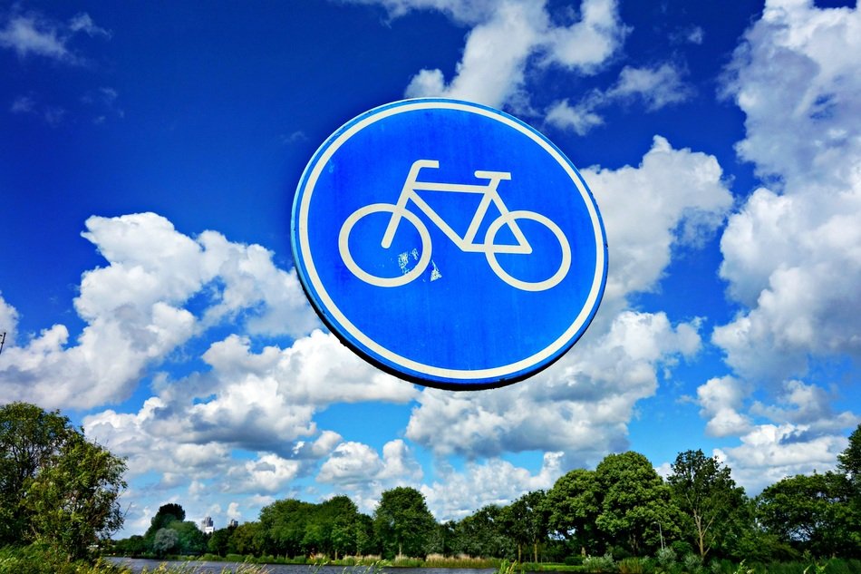 road sign with a bicycle on a background of blue sky with clouds