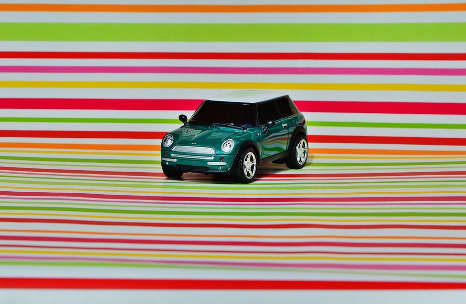 Black MINI Cooper on a background with colored stripes