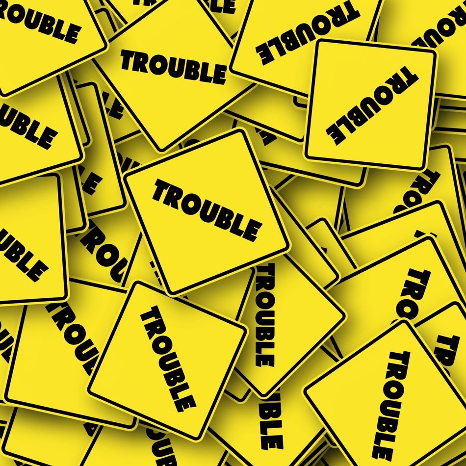 yellow road sings with text trouble