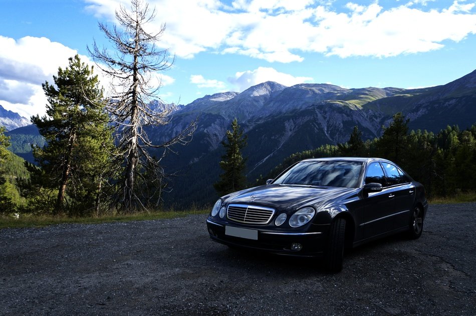 Mercedes, new black Car on road at mountain landscape