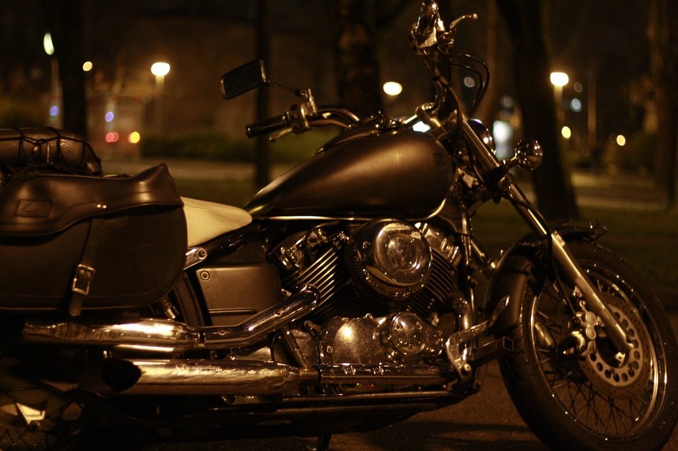 The motorcycle stands on the street at night