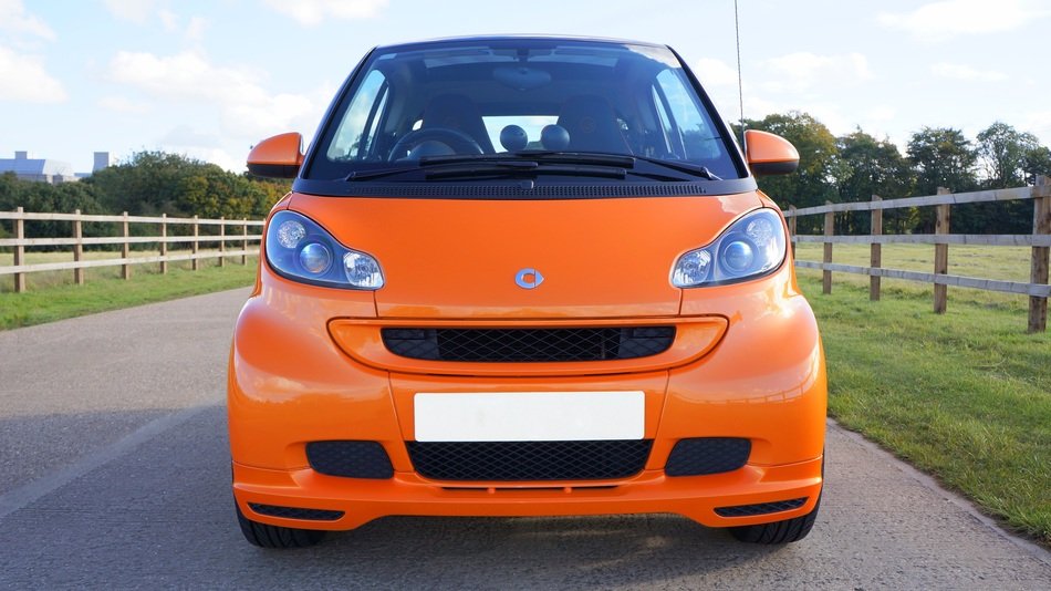 orange Smart Car on road