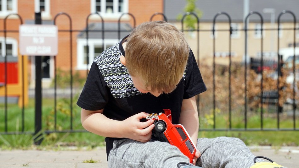 boy with a miniature model of a mini cooper