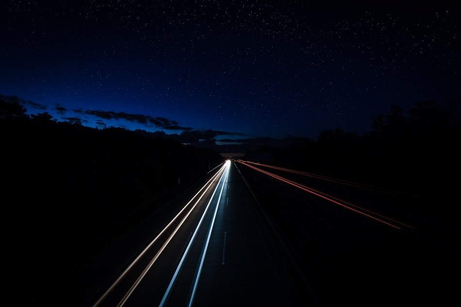 Headlights line on highway in the dark