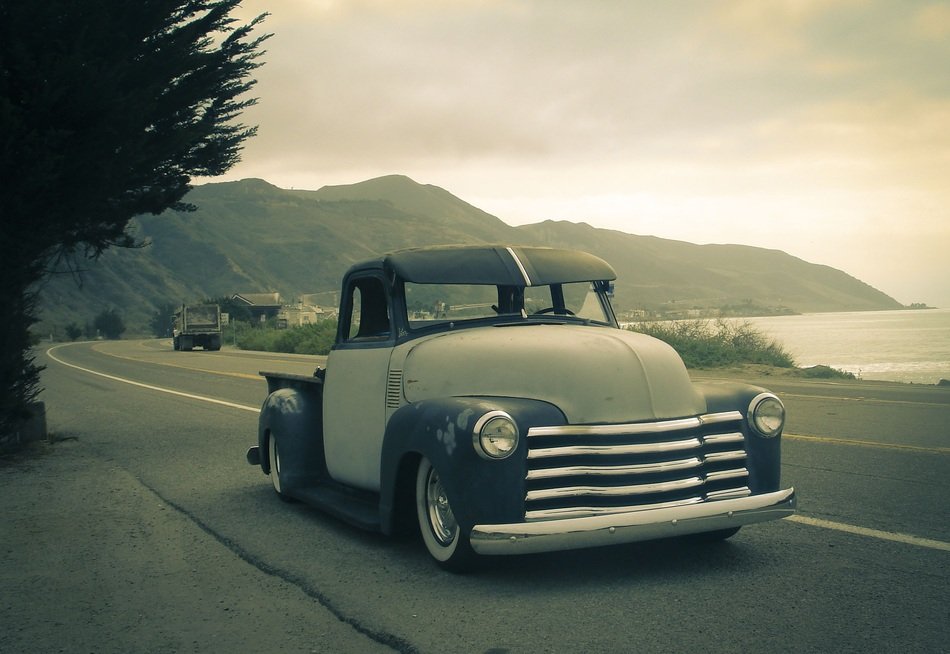 Beautiful landscape with the mountains and vintage car near the water