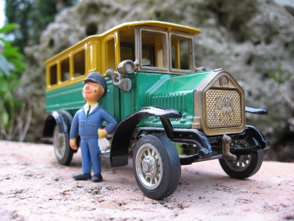 Figure of the man near the colorful macro bus with plants on the background