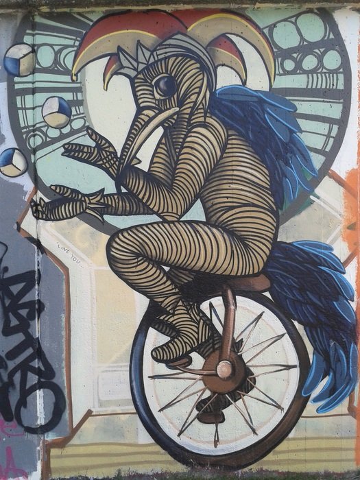 jongleur, anthropomorphic creature riding wheel, graffiti