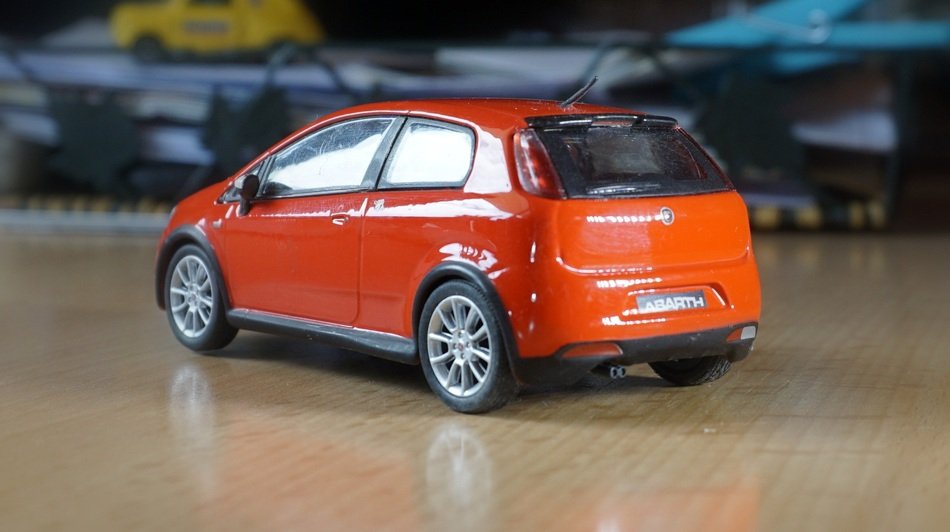 Red Italian Fiat miniature on the wooden surface