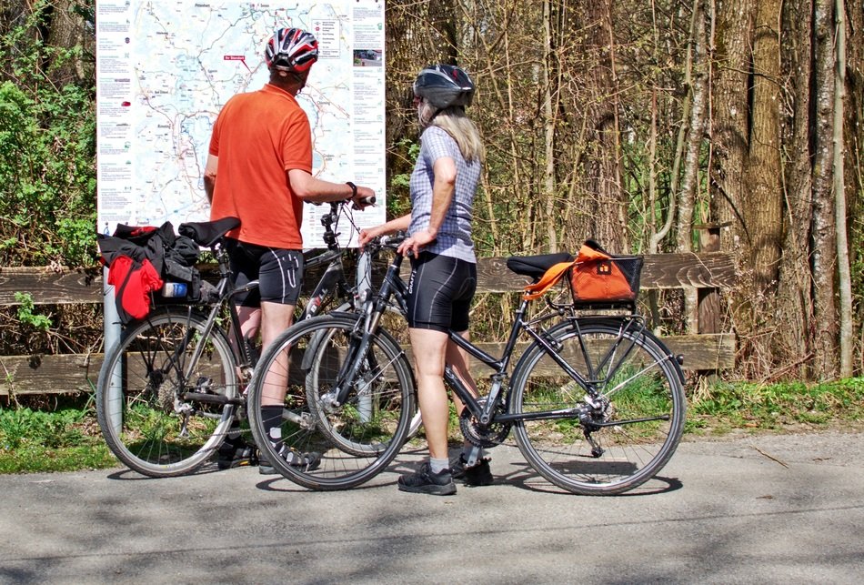 young people with bikes looking at Distance Board in park