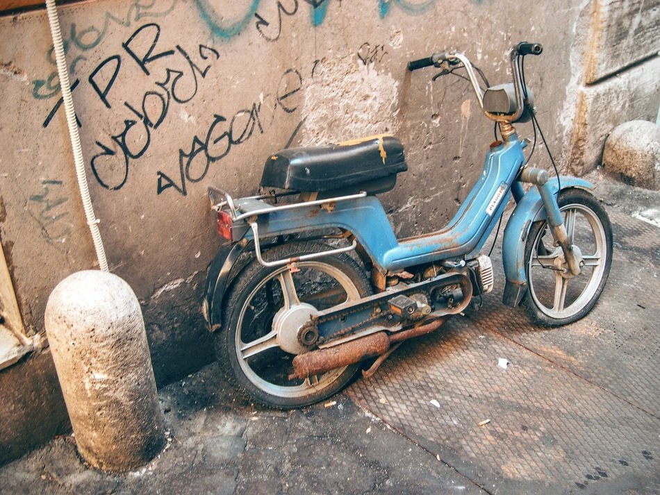 old dirty moped near the wall