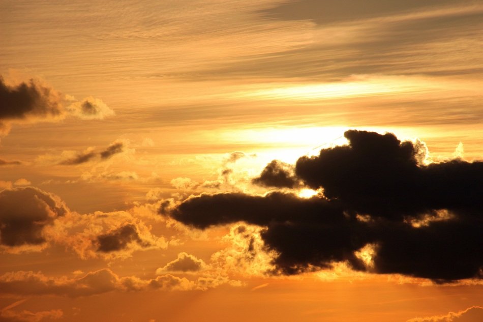 sun behind clouds in the sunset sky
