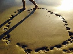 footprints on the yellow sand on a sunny day