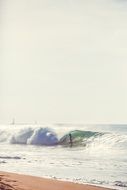 surfer on the wave on the shore of a paradise island