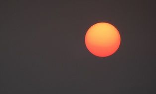 red sun on a grey sky in India