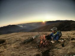 Man near the camp fire on the landscape