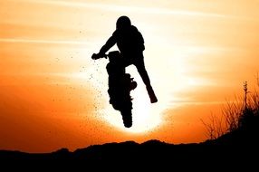 man jumping with a motorcycle during sunset