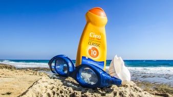 sunblock cream and goggles for swimming on the beach