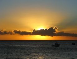 sunset sun behind a cloud over the sea